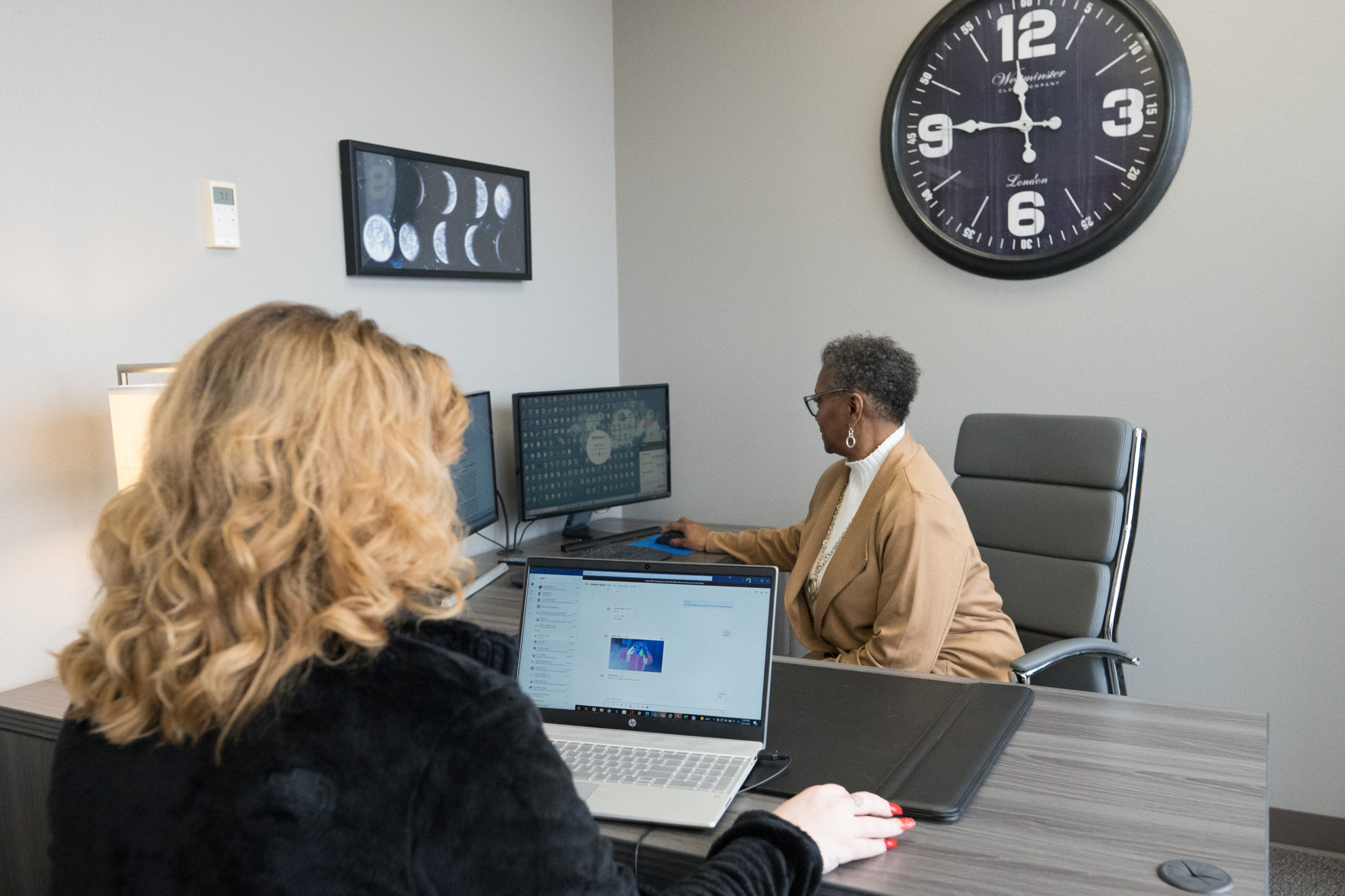 Two women working at computers in a call center